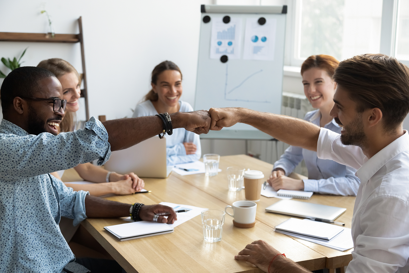 A benefits team celebrating a successful partnership decision around the conference table